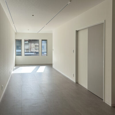 東大阪市高井田中に建つ木造2階建ての駐車場付きテナント事務所ビル外観。外壁にKMEWフィエルテを採用し、倉庫と事務所を併設した施工事例。