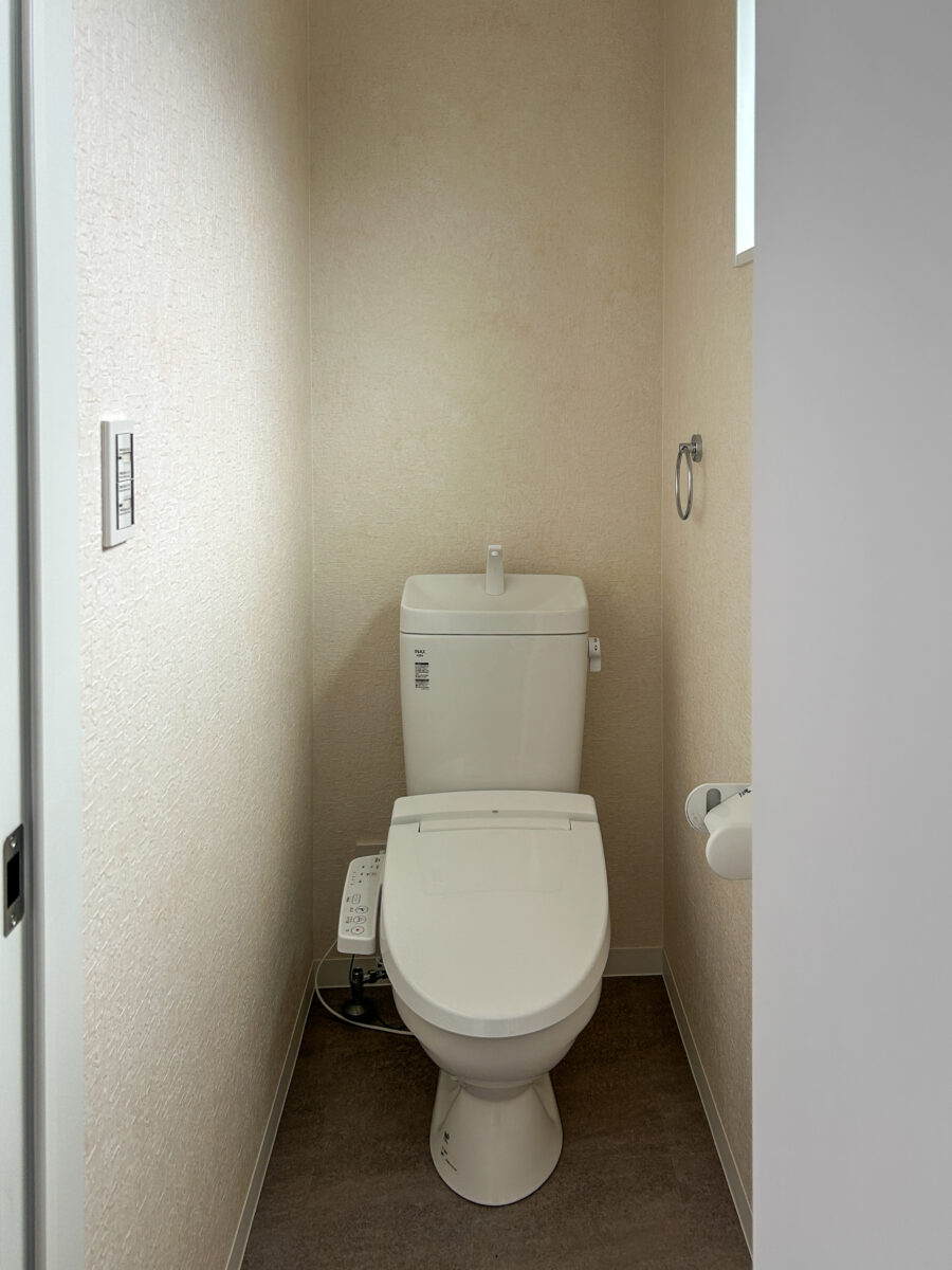 東大阪市高井田中に建つ木造2階建ての駐車場付きテナント事務所ビル外観。外壁にKMEWフィエルテを採用し、倉庫と事務所を併設した施工事例。