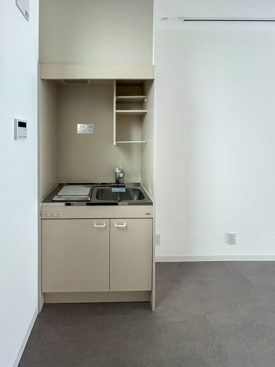 東大阪市高井田中に建つ木造2階建ての駐車場付きテナント事務所ビル外観。外壁にKMEWフィエルテを採用し、倉庫と事務所を併設した施工事例。